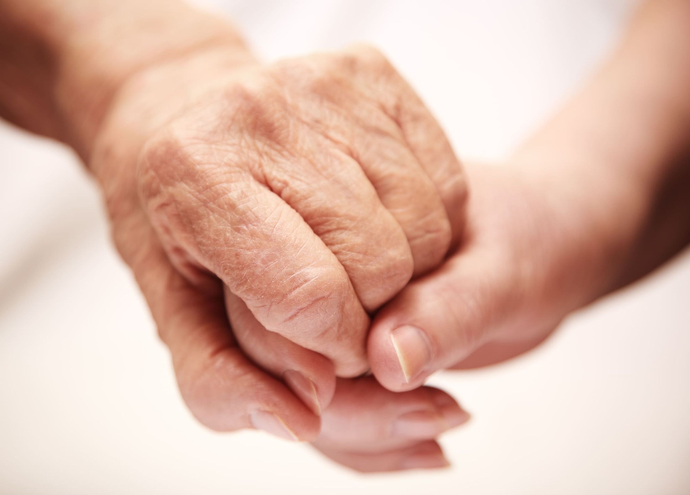 Ältere Hand hält eine junge Hand